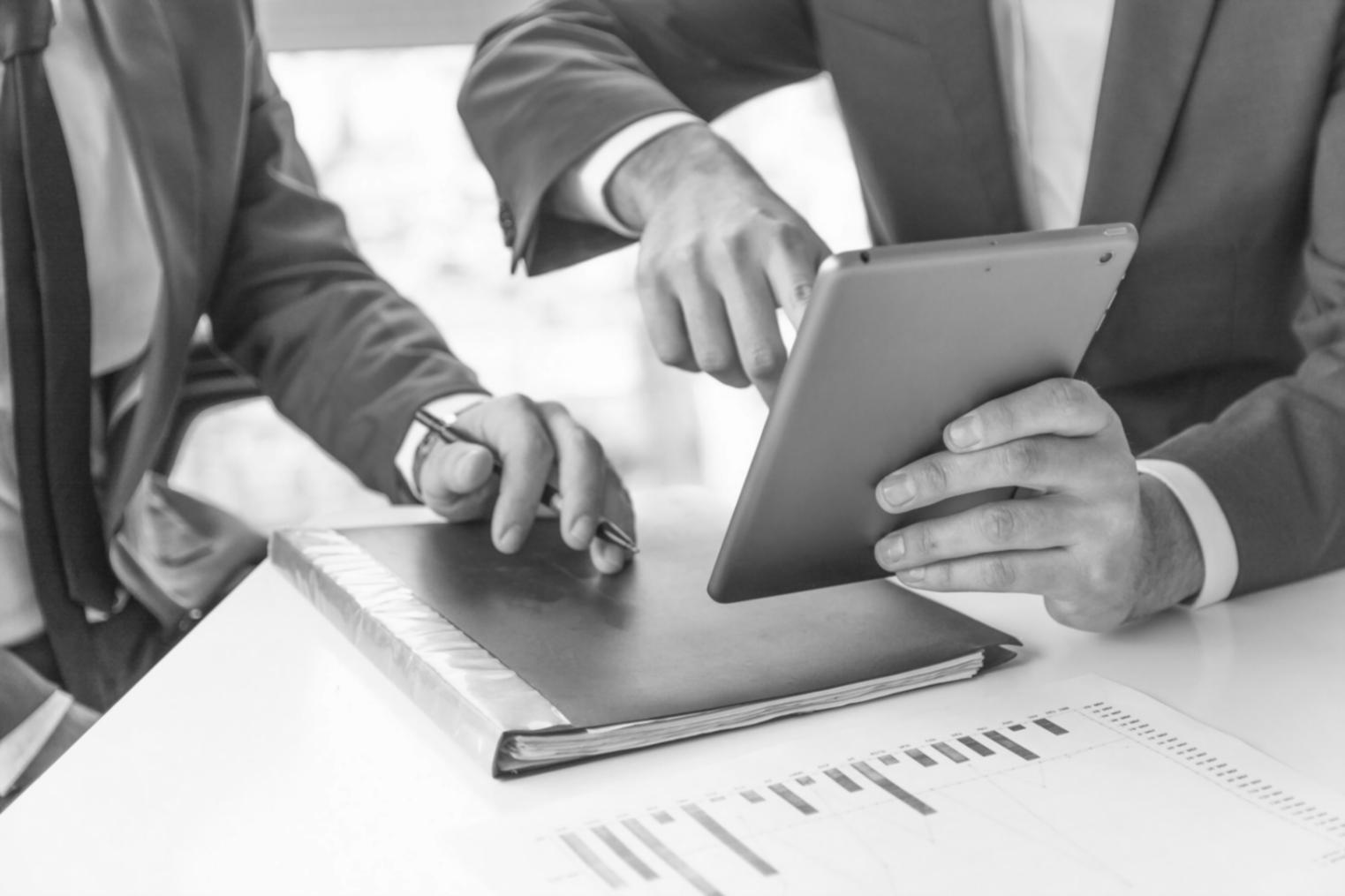 Interactive financial analysis workshop showing participants working with laptops and financial documents spread across a conference table
